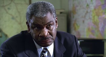 Movie still from “Bean” (1997), directed by Mel Smith – An older black man in a suit and tie; Close Up shot, Low angle