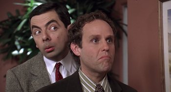 Movie still from “Bean” (1997), directed by Mel Smith – Two men in business suits looking at the camera; Close Up shot, Low angle