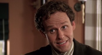 Movie still from “Bean” (1997), directed by Mel Smith – A person wearing a suit and tie; Close Up shot, High angle