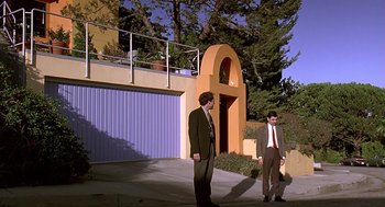 Movie still from “Bean” (1997), directed by Mel Smith – A couple of men standing next to each other on a sidewalk; Extreme Wide shot, Low angle