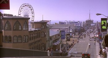 Movie still from “Bean” (1997), directed by Mel Smith – A view of a boardwalk with a ferris wheel in the background; Extreme Wide shot, High angle
