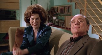 Movie still from “Bean” (1997), directed by Mel Smith – A woman sitting next to an older man on a couch; Medium shot, Low angle