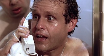 Movie still from “Bean” (1997), directed by Mel Smith – A person holding a phone up to their face; Close Up shot, Low angle