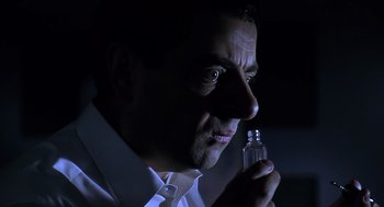 Movie still from “Bean” (1997), directed by Mel Smith – A person holding a bottle; Close Up shot, Low angle