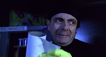 Movie still from “Bean” (1997), directed by Mel Smith – A person holding a roll of toilet paper; Close Up shot, Low angle
