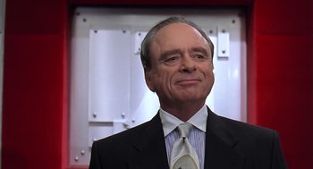 Movie still from “Bean” (1997), directed by Mel Smith – An older man in a suit and tie looking up; Close Up shot, Low angle