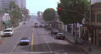 Movie still from “Bean” (1997), directed by Mel Smith – A red traffic light sitting on the side of a road; Extreme Wide shot, High angle