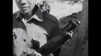 Movie still from “Summer of Soul” (2022), directed by Sanjib Gogoi – An old photo of a man holding a rifle; Extreme Close Up shot, High angle