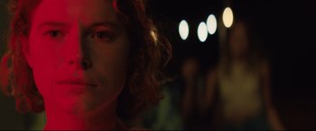 Movie still from “Beast” (2017), directed by Michael Pearce – A woman's face in the dark; Close Up shot, Over the shoulder angle