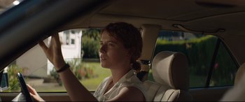 Movie still from “Beast” (2017), directed by Michael Pearce – A woman sitting in the back seat of a car; Close Up shot, Over the shoulder angle