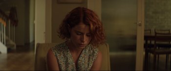Movie still from “Beast” (2017), directed by Michael Pearce – A woman with red curly hair sitting in a chair; Close Up shot, Over the shoulder angle