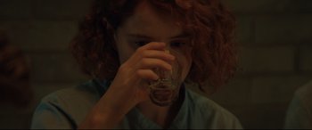 Movie still from “Beast” (2017), directed by Michael Pearce – A woman drinking a glass of water from a glass; Close Up shot, Over the shoulder angle