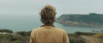 Movie still from “Beast” (2017), directed by Michael Pearce – A man standing in front of a body of water; Close Up shot, Low angle