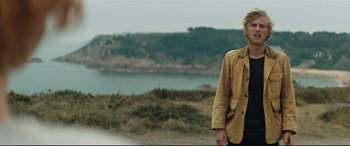 Movie still from “Beast” (2017), directed by Michael Pearce – A man standing in front of a body of water; Medium shot, Low angle