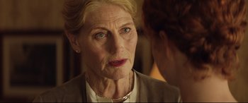 Movie still from “Beast” (2017), directed by Michael Pearce – An older woman wearing a white shirt and a necklace; Close Up shot, Over the shoulder angle