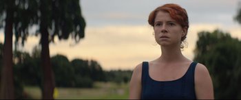 Movie still from “Beast” (2017), directed by Michael Pearce – A woman with red hair standing in front of a tree; Close Up shot, Low angle
