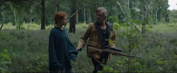 Movie still from “Beast” (2017), directed by Michael Pearce – A man and a woman walking through the woods holding hands; Medium shot, Low angle