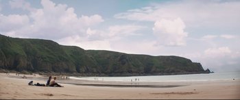 Movie still from “Beast” (2017), directed by Michael Pearce – A group of people standing on top of a sandy beach; Extreme Wide shot, Low angle