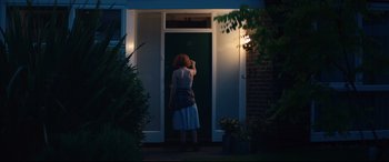 Movie still from “Beast” (2017), directed by Michael Pearce – A woman standing in front of a door at night; Wide shot, Low angle