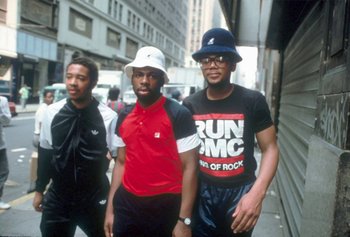 Movie still from “Beastie Boys Story” (2020), directed by Spike Jonze – A group of men walking down a street; Medium shot, Low angle