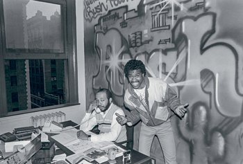 Movie still from “Beastie Boys Story” (2020), directed by Spike Jonze – A black and white photo of two men at a table; Wide shot, Low angle