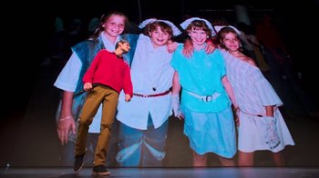 Movie still from “Beastie Boys Story” (2020), directed by Spike Jonze – A group of young people standing in front of a picture; Wide shot, Low angle