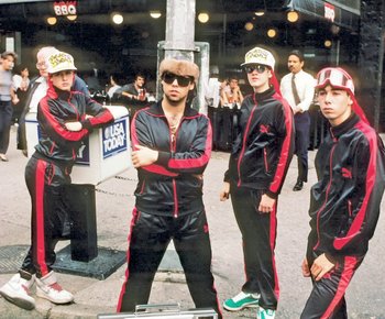Movie still from “Beastie Boys Story” (2020), directed by Spike Jonze – A group of young men standing next to each other on the street; Wide shot, Low angle