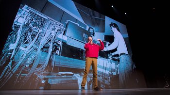 Movie still from “Beastie Boys Story” (2020), directed by Spike Jonze – A man standing in front of a large screen; Wide shot, Low angle