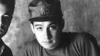 Movie still from “Beastie Boys Story” (2020), directed by Spike Jonze – A young man wearing a baseball cap and a t - shirt; Close Up shot, Overhead angle