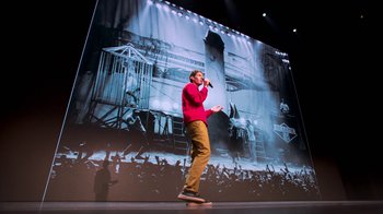 Movie still from “Beastie Boys Story” (2020), directed by Spike Jonze – A man standing on a stage singing into a microphone; Wide shot, Low angle