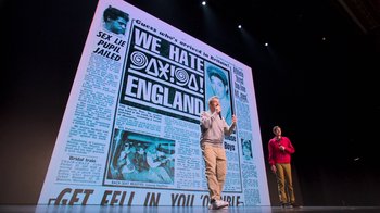Movie still from “Beastie Boys Story” (2020), directed by Spike Jonze – A man standing in front of a large poster of a newspaper; Wide shot, Low angle