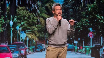 Movie still from “Beastie Boys Story” (2020), directed by Spike Jonze – A man standing in front of palm trees holding a microphone; Medium shot, Low angle