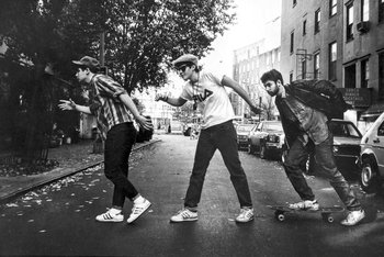 Movie still from “Beastie Boys Story” (2020), directed by Spike Jonze – A group of young men riding skateboards down a street; Wide shot, Low angle