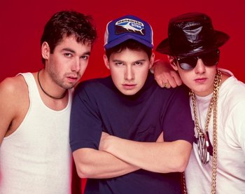 Movie still from “Beastie Boys Story” (2020), directed by Spike Jonze – A group of young men standing next to each other on a red background; Medium shot, Low angle