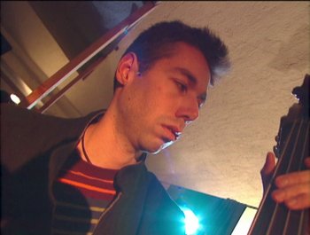 Movie still from “Beastie Boys Story” (2020), directed by Spike Jonze – A man looking at his cell phone while standing on stairs; Close Up shot, Low angle