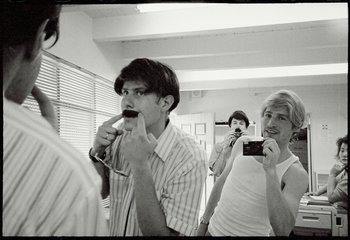 Movie still from “Beastie Boys Story” (2020), directed by Spike Jonze – A group of people standing in a room taking pictures; Close Up shot, Low angle