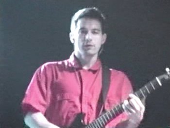 Movie still from “Beastie Boys Story” (2020), directed by Spike Jonze – A man in a red shirt is playing an electric guitar; Close Up shot, Low angle