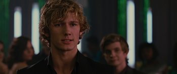 Two young men standing next to each other in a dark room