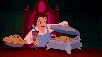 Movie still from “Beauty and the Beast” (1991), directed by Kirk Wise – A woman holding a piece of cake in front of a pie; Medium shot, Overhead angle