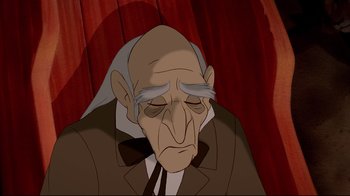 Movie still from “Beauty and the Beast” (1991), directed by Kirk Wise – An old man is sitting down with his eyes closed; Close Up shot, Over the shoulder angle