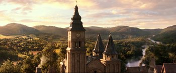 Movie still from “Beauty and the Beast” (2017), directed by Bill Condon – An aerial view of an old church with a clock tower; Extreme Wide shot, High angle