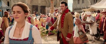 Movie still from “Beauty and the Beast” (2017), directed by Bill Condon – A man dressed in period clothing holding a bunch of flowers; Medium shot, Over the shoulder angle