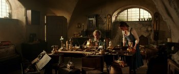 Movie still from “Beauty and the Beast” (2017), directed by Bill Condon – A man sitting at a table with a woman standing next to him; Wide shot, Low angle
