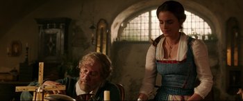 Movie still from “Beauty and the Beast” (2017), directed by Bill Condon – An old man sitting next to a woman in a room; Medium shot, Low angle
