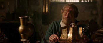 Movie still from “Beauty and the Beast” (2017), directed by Bill Condon – An older man is holding a wooden stick; Medium shot, Over the shoulder angle