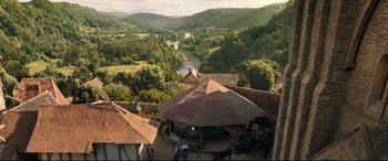 Movie still from “Beauty and the Beast” (2017), directed by Bill Condon – An aerial view of a river and mountains with a gazebo in the foreground; Extreme Wide shot, High angle