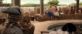 Movie still from “Beauty and the Beast” (2017), directed by Bill Condon – A woman and a little girl sitting on a stone bench; Wide shot, High angle