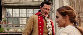 Movie still from “Beauty and the Beast” (2017), directed by Bill Condon – A man in a red and brown jacket and a woman in a red and white dress; Medium shot, Over the shoulder angle