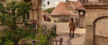 Movie still from “Beauty and the Beast” (2017), directed by Bill Condon – A group of people standing in a dirt field; Wide shot, High angle