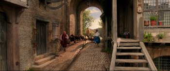Movie still from “Beauty and the Beast” (2017), directed by Bill Condon – A painting of people herding goats down a street; Wide shot, Over the shoulder angle